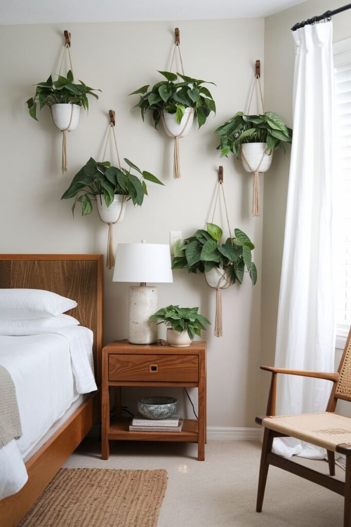 Multiple potted plants are hung on the wall using macrame hangers, arranged in a cluster near the bed and nightstand.