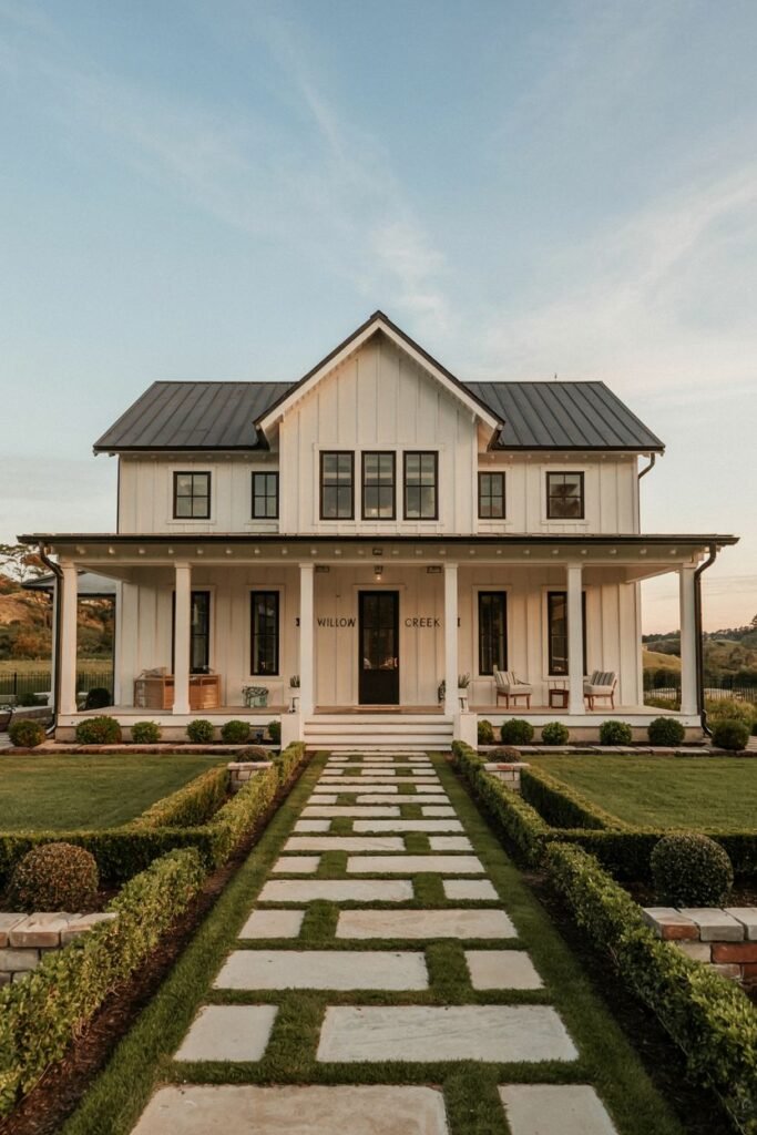 A white two-story modern farmhouse with dark windows, a dark metal roof, and a deep covered porch supported by white columns, featuring a striking stone path leading to the entrance. The house sign reads "S WILLOW CREEK E".