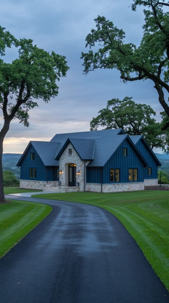 Large country house with deep blue vertical siding and light-colored stone accents.