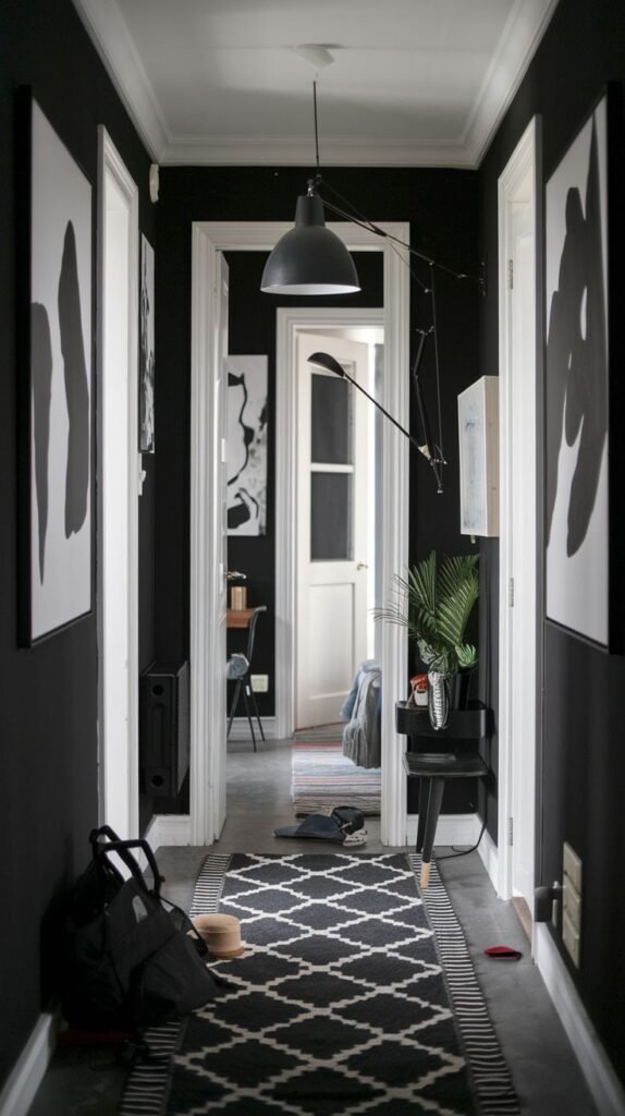 A dynamic Black and White hallway features dark walls, white trim, and a patterned rug with a geometric design. A modern black wall-mounted lamp extends into the space, illuminating the area.
