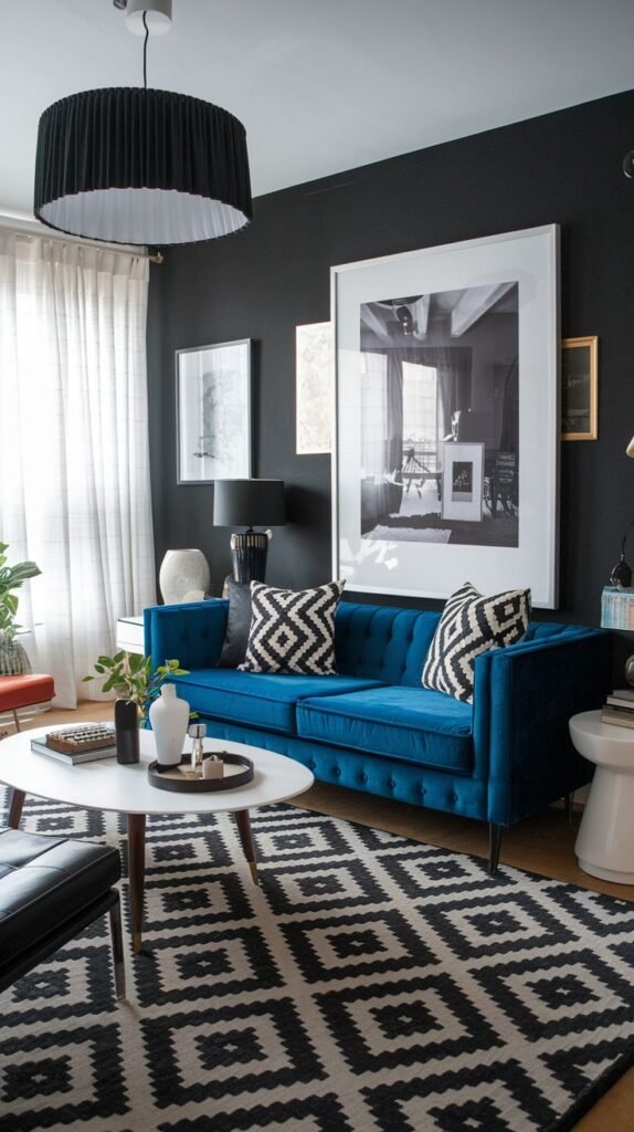 A dynamic Black and White living room features dark walls providing a striking backdrop for a vibrant blue velvet sofa. The floor is covered by a large Black and White geometric patterned rug, and Black and White throw pillows echo the rug's design, creating a cohesive and modern space.
