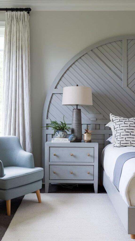 An elegant and inviting bedroom with a unique arched Grey Headboard featuring diagonal wooden slats, a matching nightstand, and a comfortable armchair.