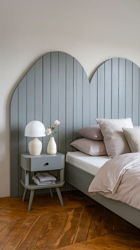 A charming and elegant bedroom with a whimsical double-arch Grey Headboard made of vertical wooden planks, paired with a matching nightstand and a modern lamp.