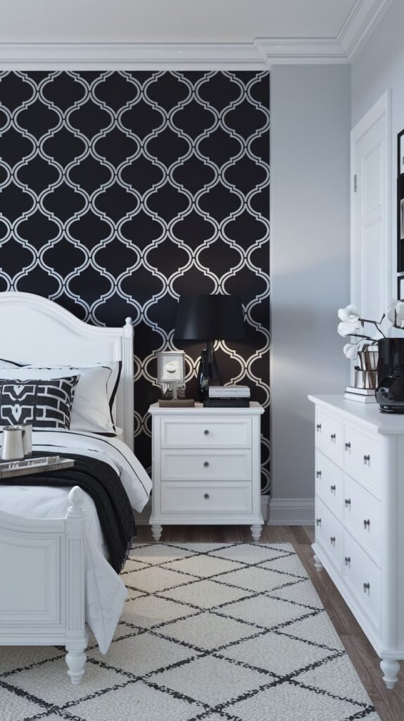 An Apartment One Bedroom featuring striking black and white quatrefoil patterned wallpaper, a white bed with a decorative headboard, a white nightstand, and a matching white dresser.