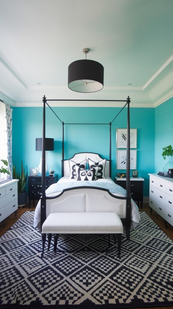A teal bedroom with a black four-poster bed. The bed has a white upholstered headboard with black accents and black and white patterned pillows. A black and white geometric patterned rug covers the floor. White dressers are on either side of the bed, and a black drum pendant light hangs from the ceiling.