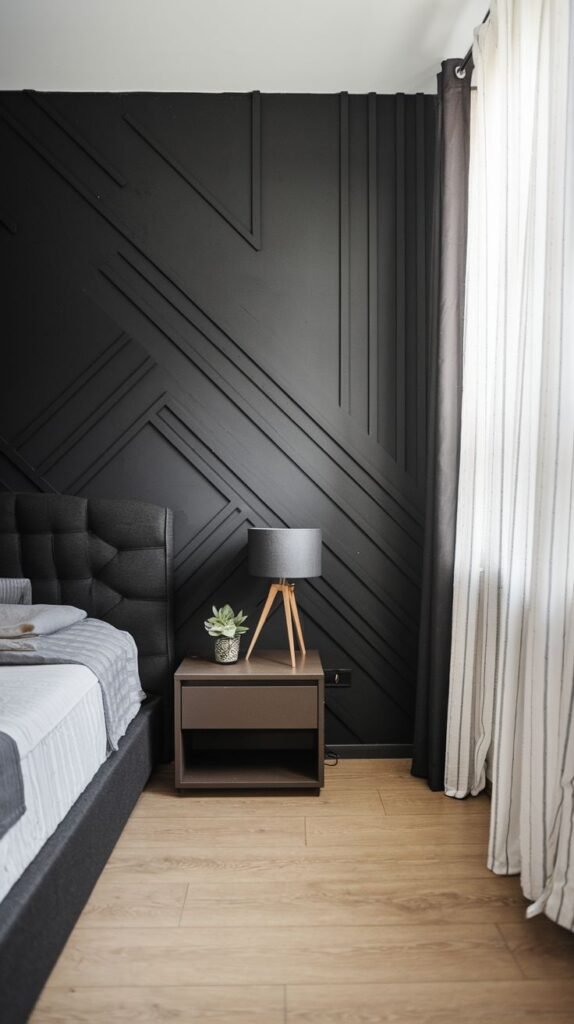 A matte black accent wall with thin, raised molding strips applied in angular, crisscrossing diagonal lines to create subtle dimensional texture.