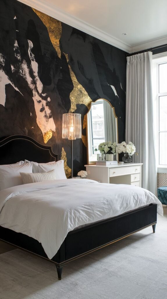 A luxurious bedroom featuring a black accent wall with a striking mural of abstract, fluid swirls in gold, black, and touches of pink/white, set behind a black velvet bed with white bedding.