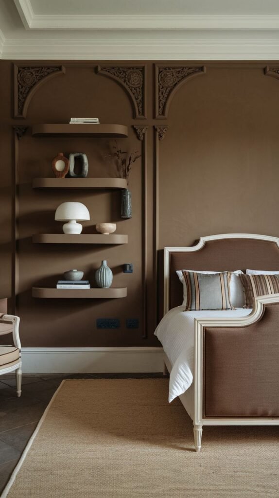 A solid brown accent wall featuring subtle architectural trim that defines vertical panels and includes decorative carved detailing near the ceiling, with matching floating shelves integrated into the design.