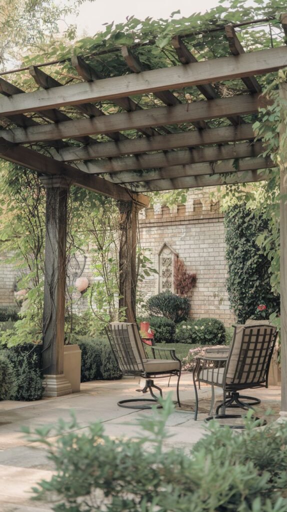 Rustic pergola with vine-wrapped timber posts, shading a cozy seating area of two swivel chairs, set against a background of a light brick privacy wall with castle-style architectural details.