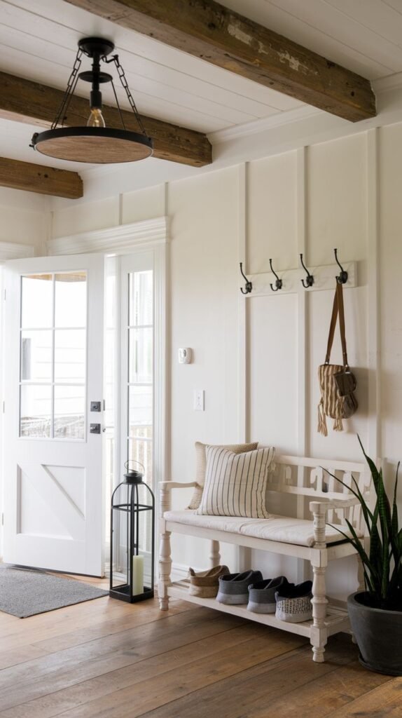 Modern Farmhouse Entryway with white vertical paneling and ceiling planks, exposed wood beams, a traditional white bench, coat hooks, and a tall black metal floor lantern.