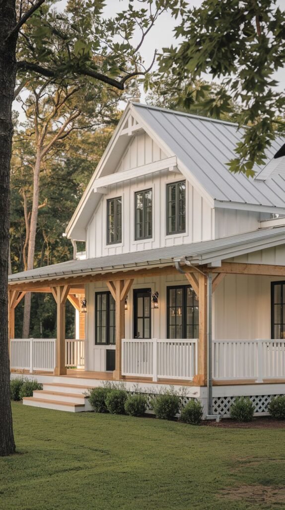 White farmhouse with a light metal roof and an extended covered porch. The porch is characterized by chunky, unpainted natural wood posts and beams contrasting with crisp white balustrade railings.