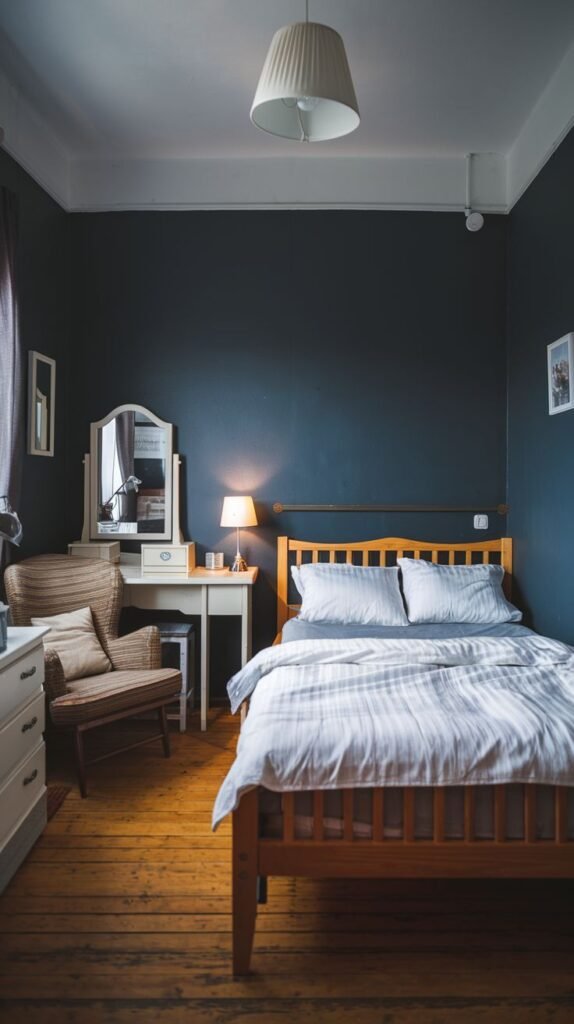 Warm, dark-walled Cozy Small Bedroom For Men with wood plank flooring, a simple wooden bed frame, and a white vintage dressing table/vanity.