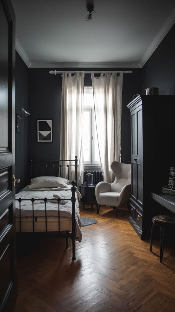 European-style Cozy Small Bedroom For Men featuring black walls, herringbone wood flooring, a black metal bed, and long, light-colored curtains highlighting the window.