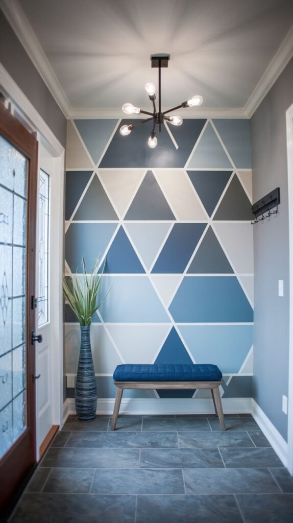 Entryway accent wall painted with a seamless, floor-to-ceiling geometric mural of interlocking triangles in various shades of blue, gray, and white.