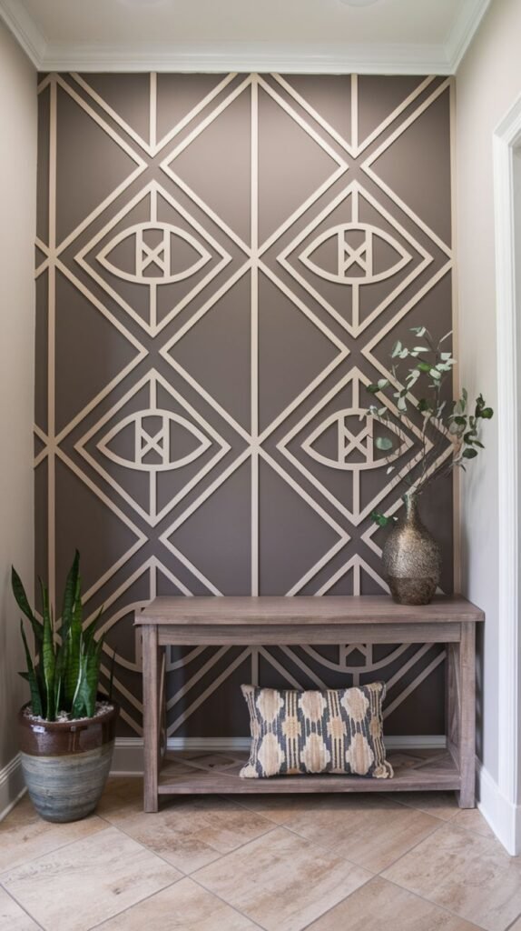 Accent wall painted taupe/brown featuring intricate light wood trim creating a repeating pattern of stylized diamond and eye motifs, set behind a wooden console table.