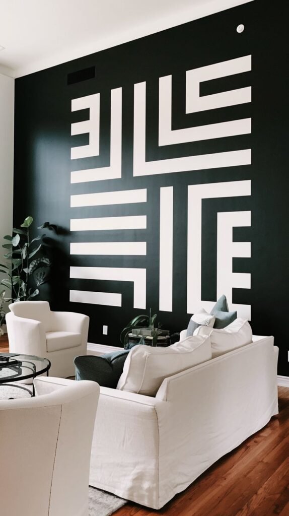 High black accent wall displaying a massive white geometric pattern made of interlocking, linear straight-line segments, behind a white slipcovered sofa.