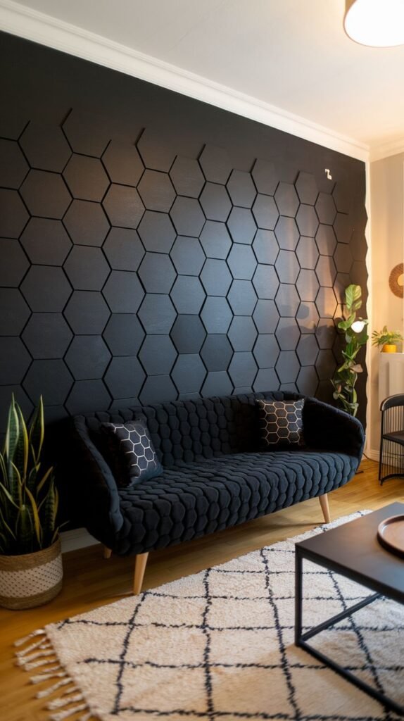 Textural black accent wall covered entirely in black 3D hexagonal (honeycomb) panels, complemented by a matching textured black sofa.