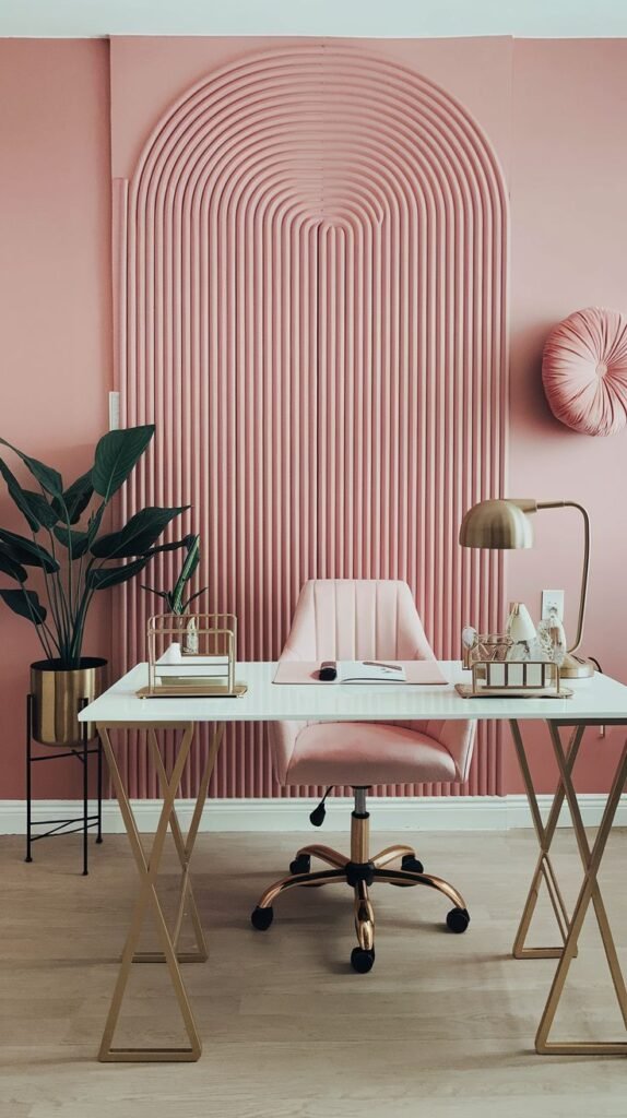 Soft pink accent wall featuring a dimensional, arched panel composed of closely spaced vertical fluted rods, creating a subtle 3D effect behind the office chair.