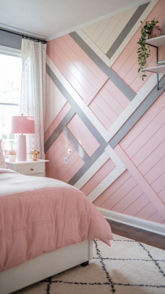 A close-up of a dynamic accent wall featuring a pink diagonal shiplap base overlaid with a geometric pattern created by crisscrossing white and gray trim boards.