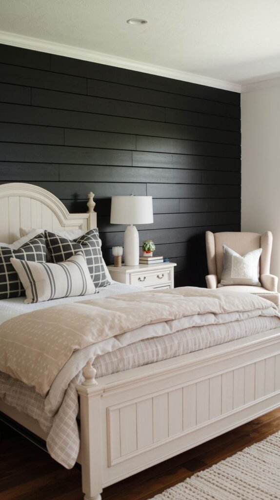 A classic bedroom featuring a large white wooden bed frame and neutral linens positioned against a dramatic black horizontal shiplap accent wall.