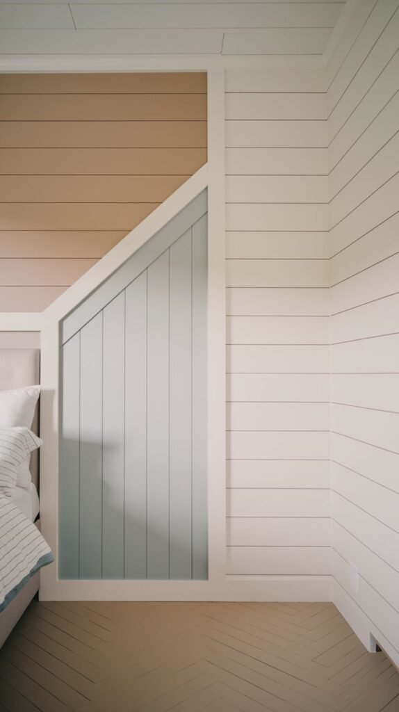 A close-up of a highly decorative wall design featuring tan horizontal shiplap combined with a central angled panel of light gray vertical shiplap/paneling, framed by white trim.
