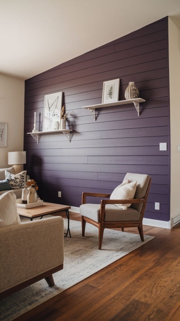 A bold accent wall of horizontal shiplap painted in a deep, vibrant purple (aubergine), decorated with two white floating shelves.