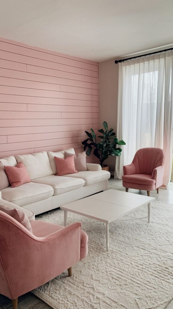 A modern, feminine living room featuring a horizontal shiplap wall painted a soft pastel pink, paired with white and pink velvet seating.